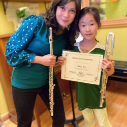 flute level flute teacher and flute student holding a certificate