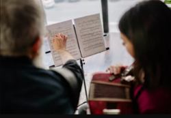 music theory a music teacher and student reading music sheets from a music stand