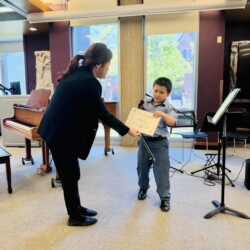 violin level violin teacher and violin student holding a certificate
